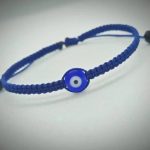Pulsera ajustable tejida a mano en hilo azul marino con dije de ojo turco