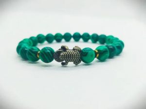 2026/01/1002486884.jpg Pulsera elástica de piedras naturales malaquita, hematitas doradas y dije de Sapo en oro viejo