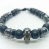 Pulsera ajustable de piedras naturales ónix mate, hematitas y dije de calavera plateada